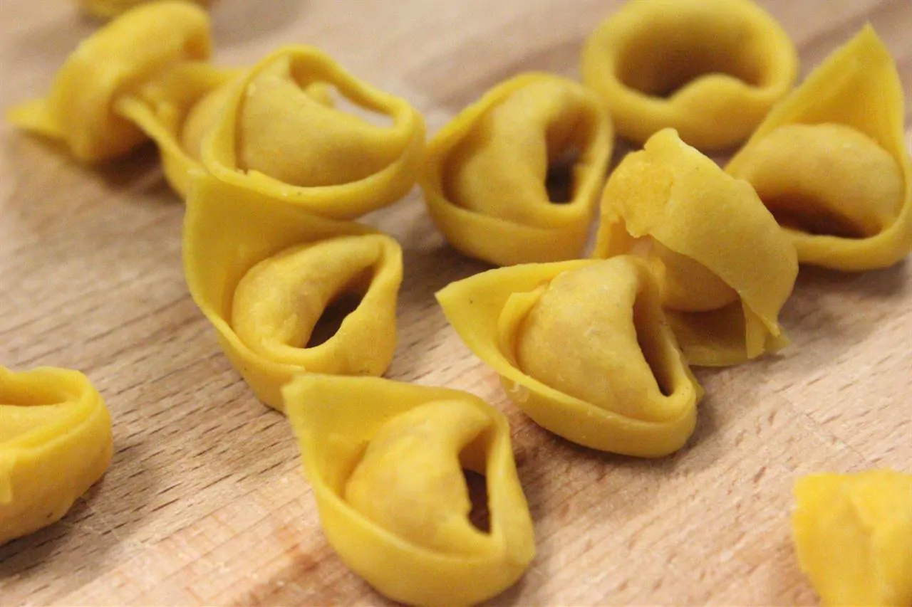 Tortellini appena chiusi: la sfoglia si tira ancora a mano nelle sfoglierie di paese